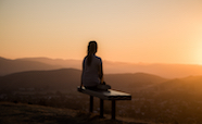 Person sitting alone near dusk on a hilltop thumb