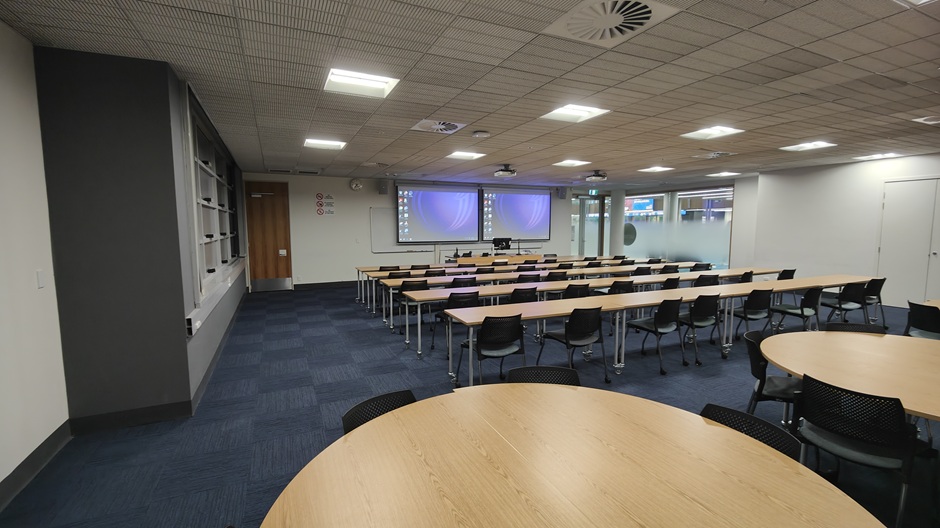 View of Otago Business School room G17, showing tables and chairs in rows and groups