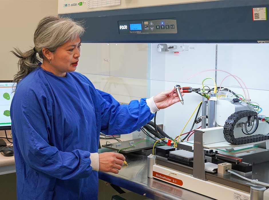 a woman working with a bioprinter 