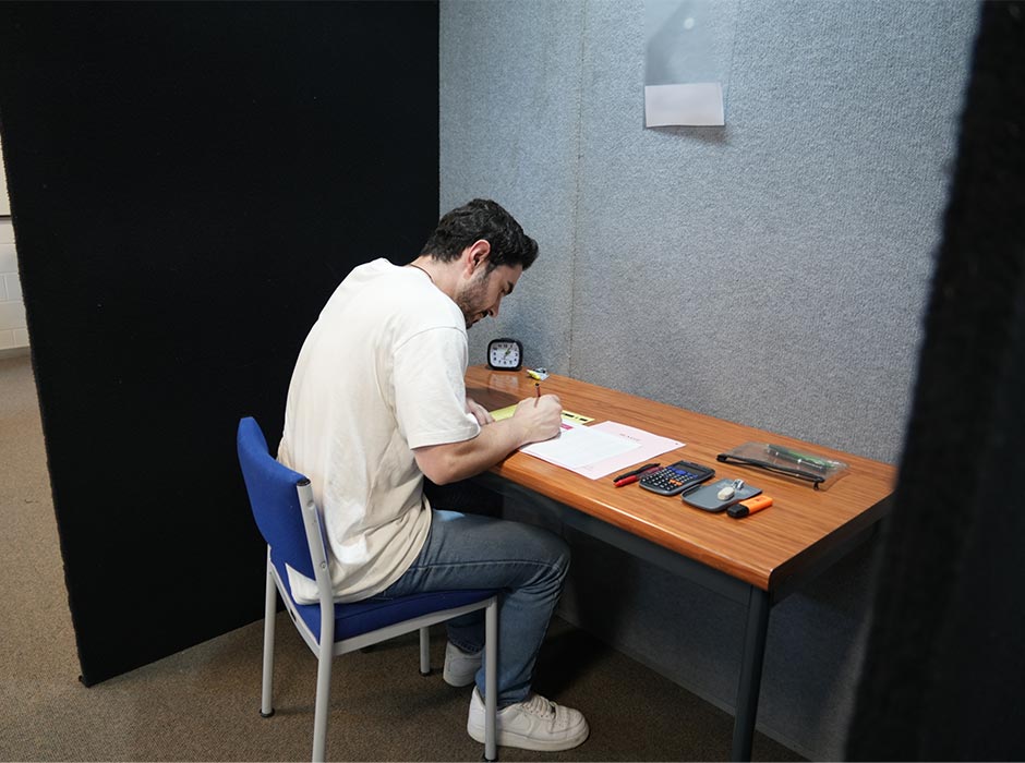 Nate Hamilton, demonstrating one of the new spaces, says the booth gave him peace of mind and no distractions during his actual exam.