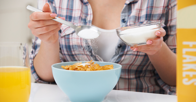 Woman adding sugar to cereal