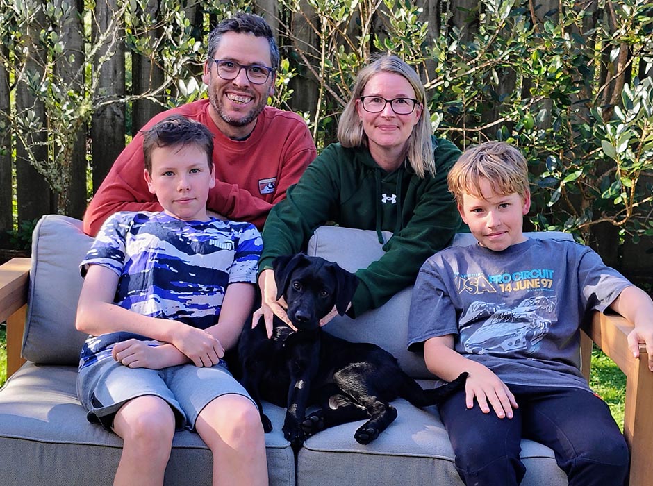 A family portrait- husband, wife, two sons, and their new puppy