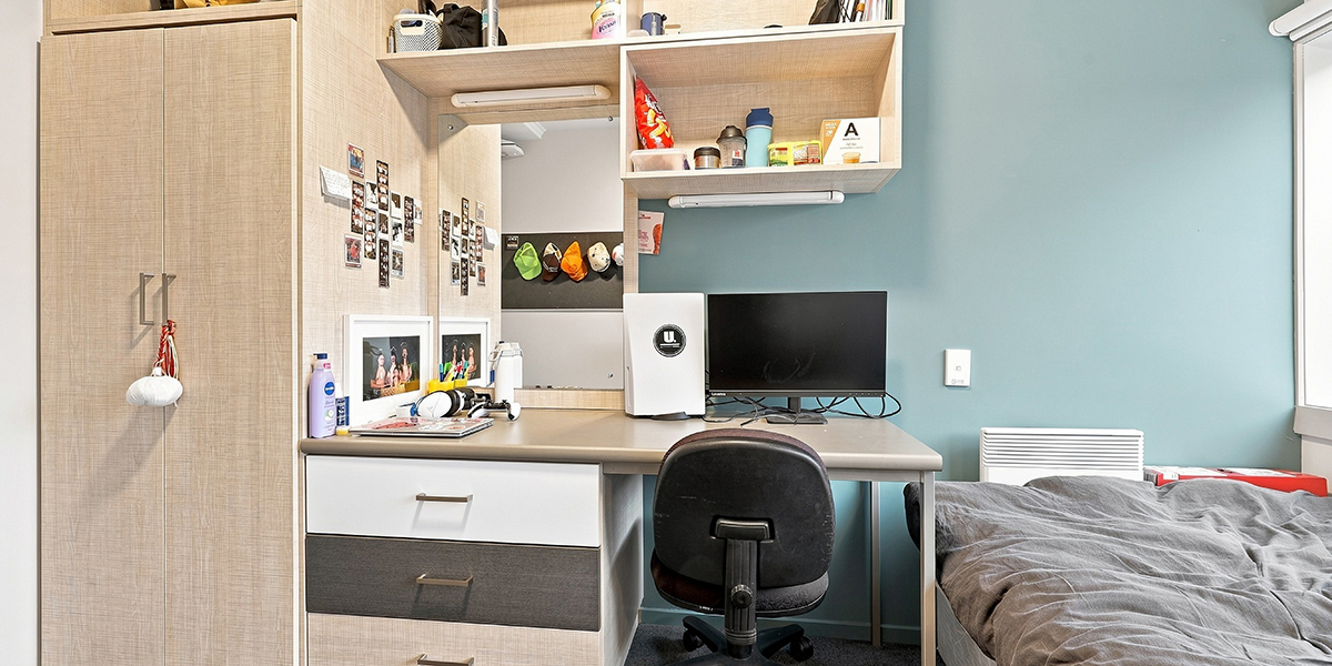 Student bedroom with bed and desk area