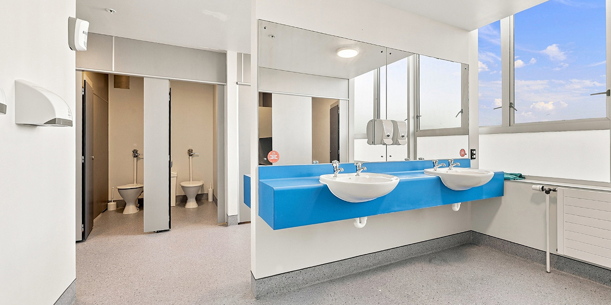 Shared bathroom facilities with sinks and toilet cubicles