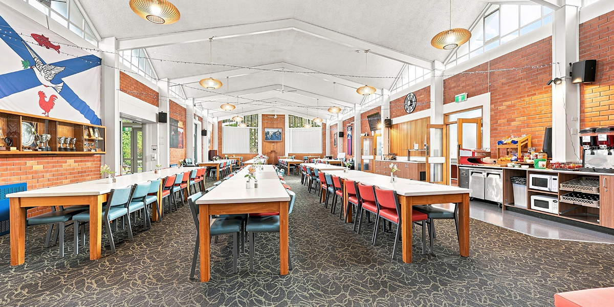 Dining hall with tables and chairs and tea, coffee and toast preparation area