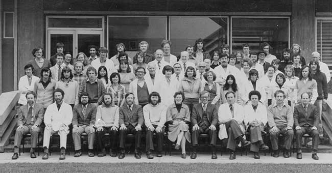 A black and white photo of five rows of people standing on stairs for a photo
