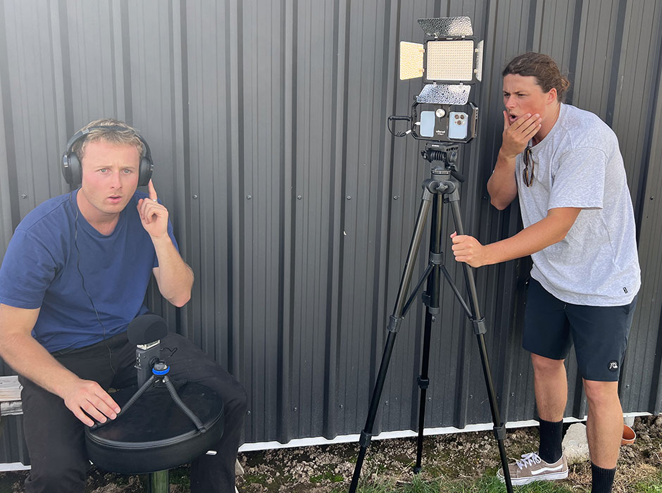 Two men, one using audio equipment and the other using a camera