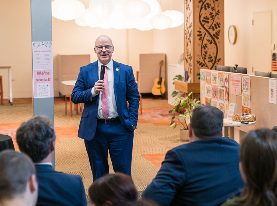 A man addresses a crowd at the new wellbeing hub.