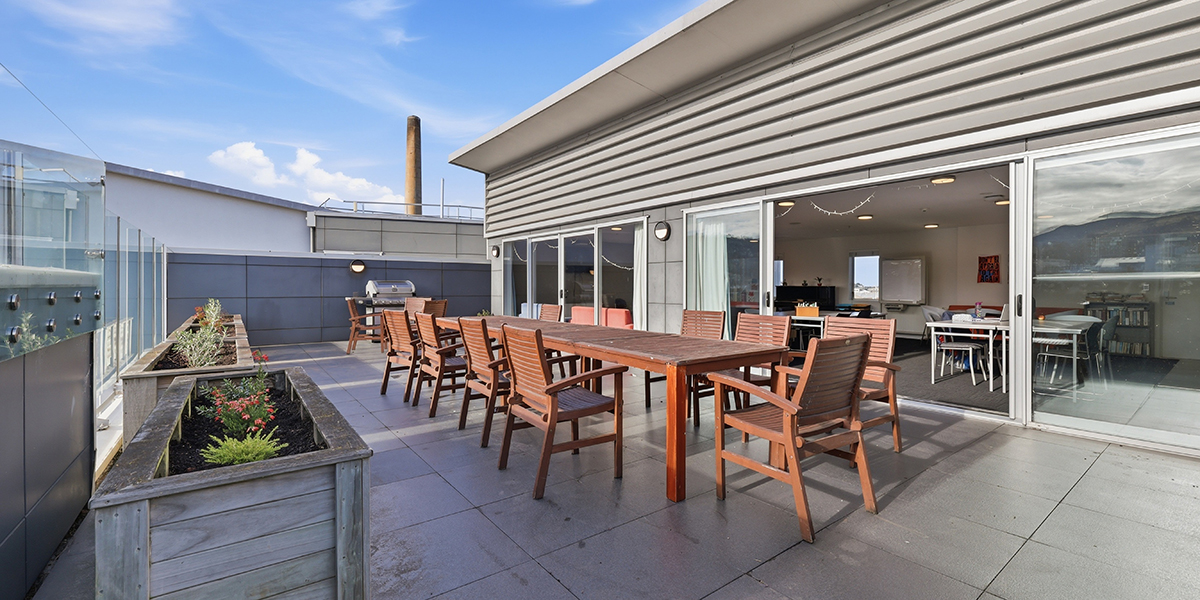 Outdoor deck area with table and chairs accessible from common room