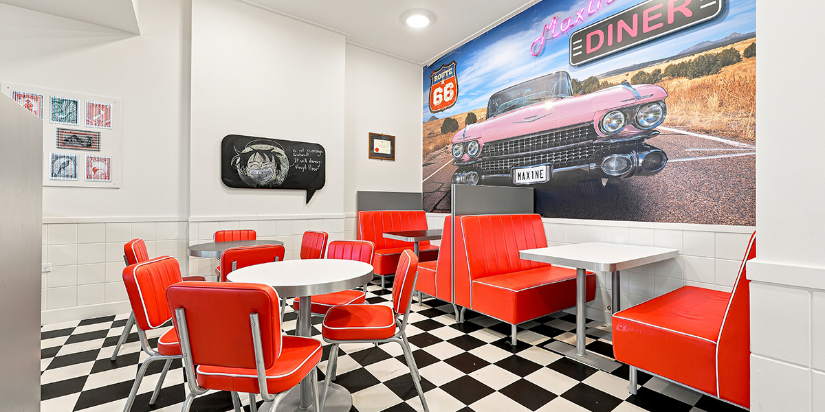 Diner-style eating area with red seating and black and whitetiled floor