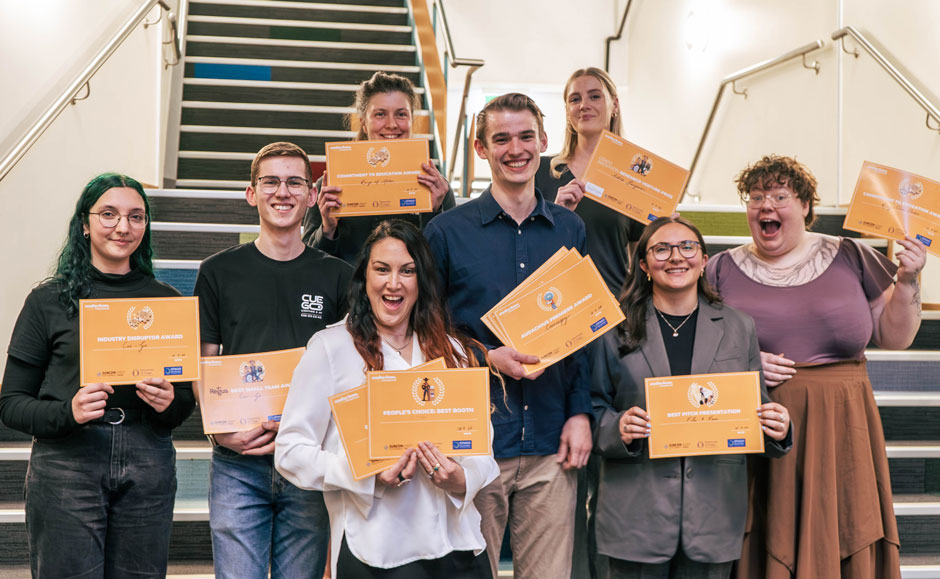 Group shot of Audacious students holding their certificates on a flight of stairs.