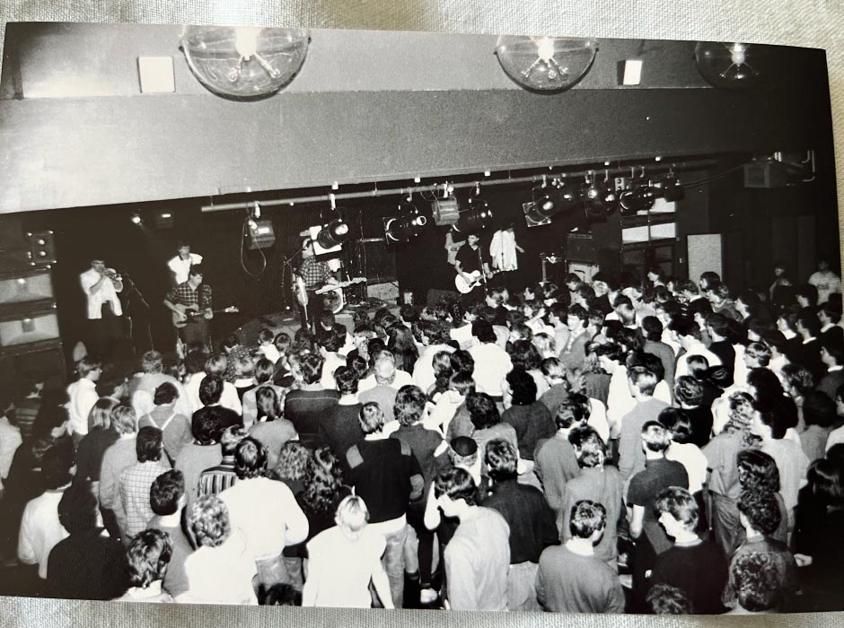 A band plays for students at a music gig in the 1980s.
