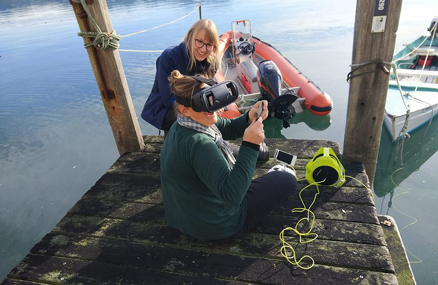 2 females sitting on the wharf with technical  marine equipment 1x
