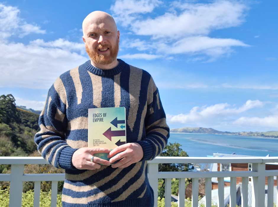 A man standing holding his book 