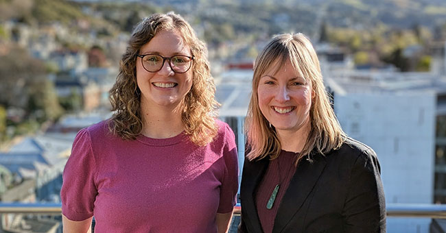 Two women standing on a balcony 