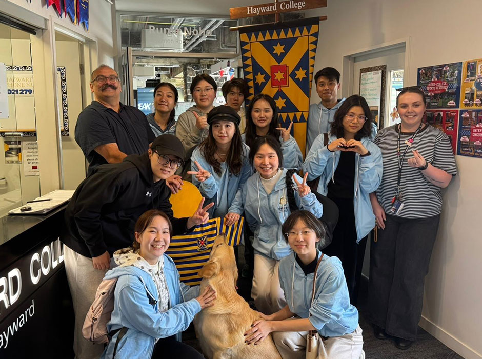 A group of people clustered together in an entrance way smiling at the camera 