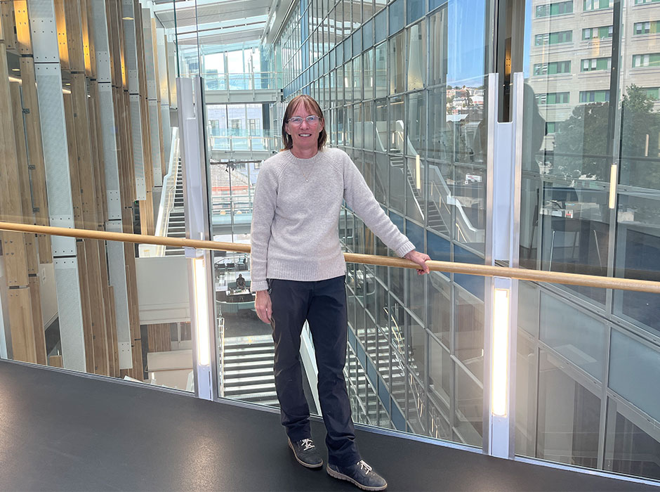 A woman standing in a building that has a lot of glass 