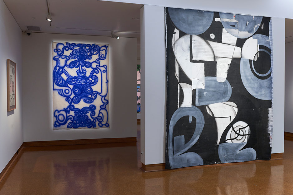 Two large paintings, one with black white and grey shapes the other with twirly blue linework.
