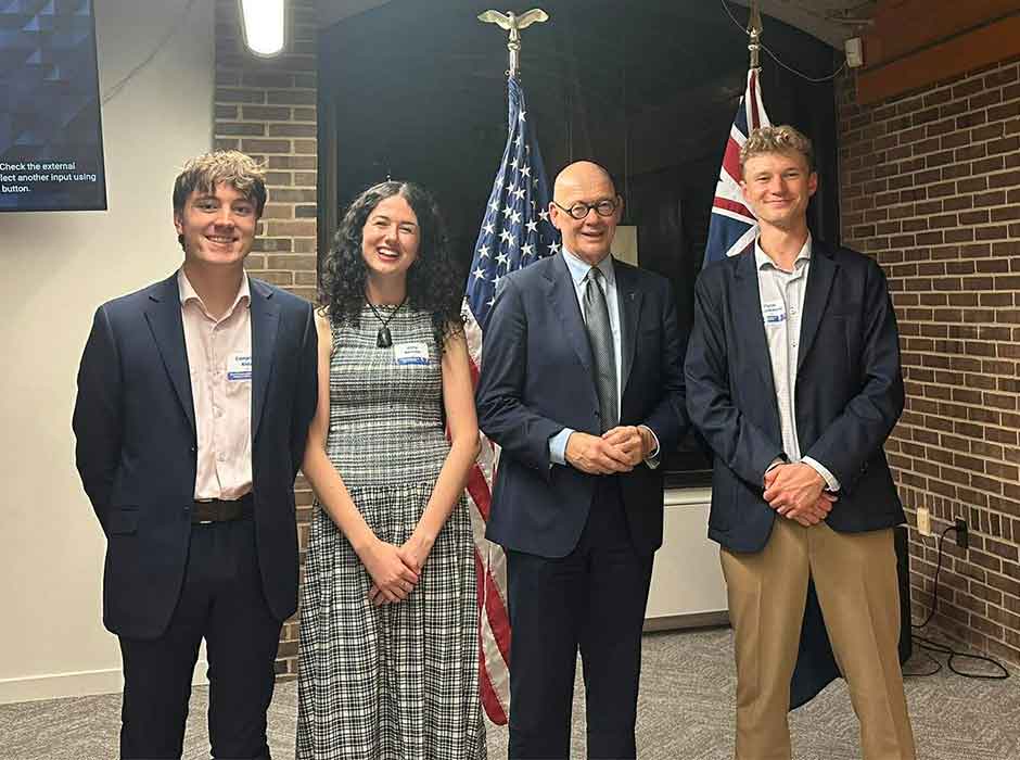 four people standing next to each other 