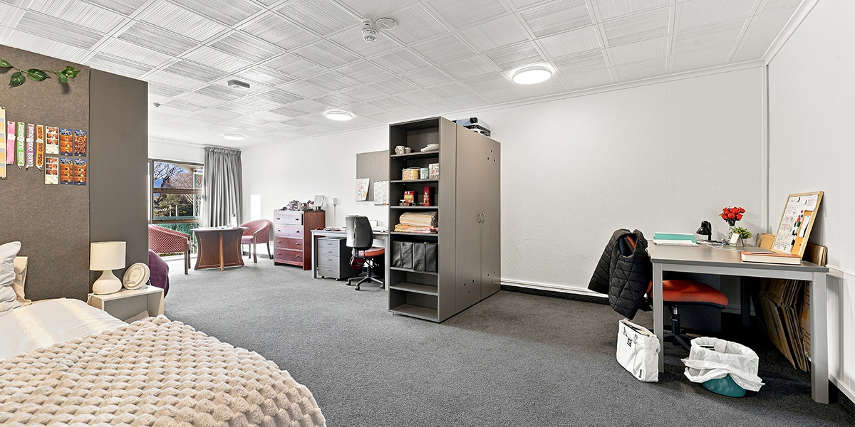 Shared bedroom with two beds, shelving and desks