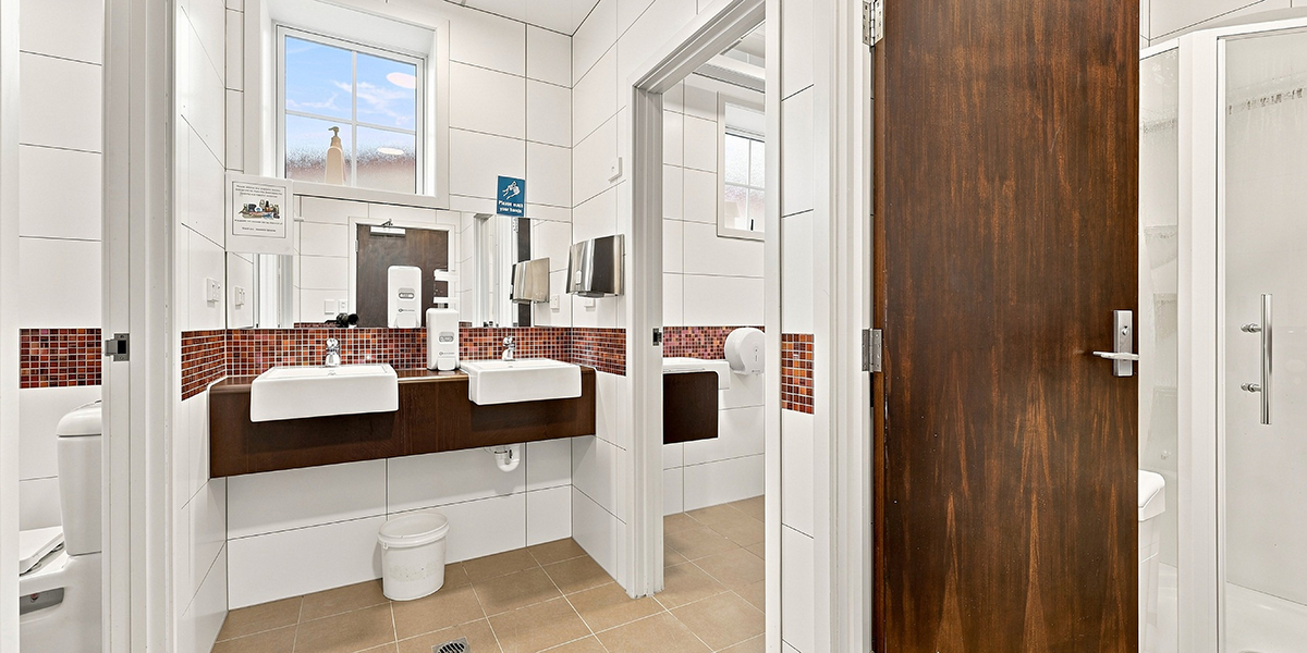 Shared bathroom facilities with sinks and indivdual bathroom cubicles