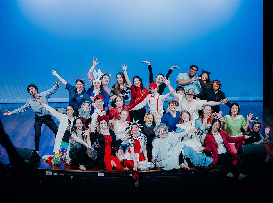 a group of people gathered on a stage in various costumes to promote their upcoming show