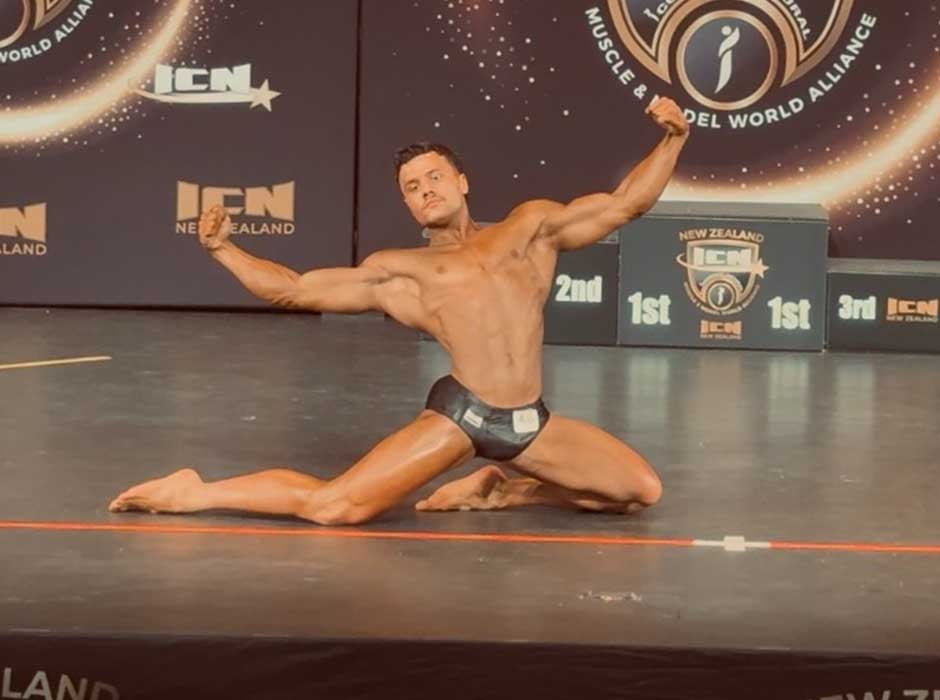  a man on a stage holding a pose during a bodybuilding competition