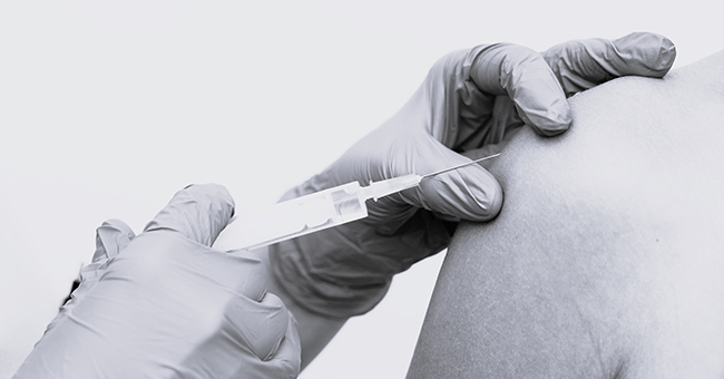 Medical professional administering vaccination into a persons arm