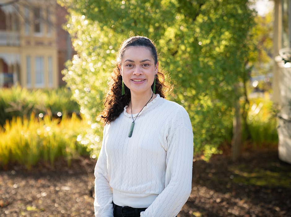 Young Māori woman standing with trees in the background