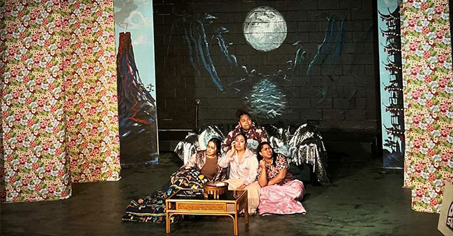 Four women perform on a stage.