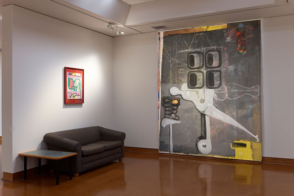 Large room with two abstract paintings, one small the other fills up the whole wall.