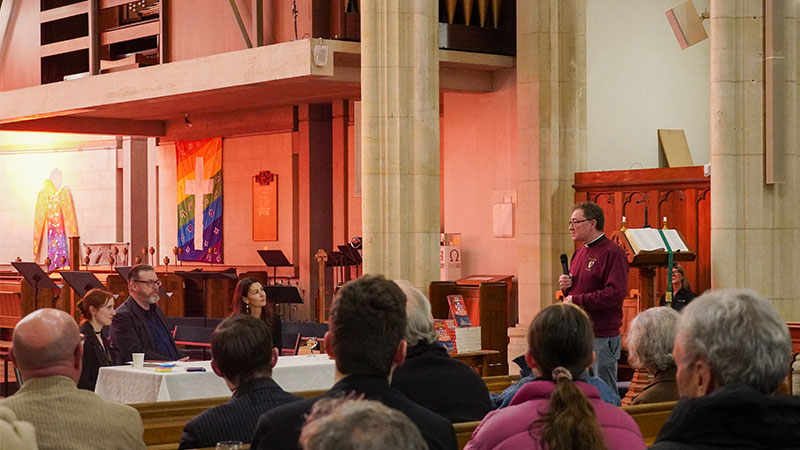 A man speaks to an audience in the cathedral.