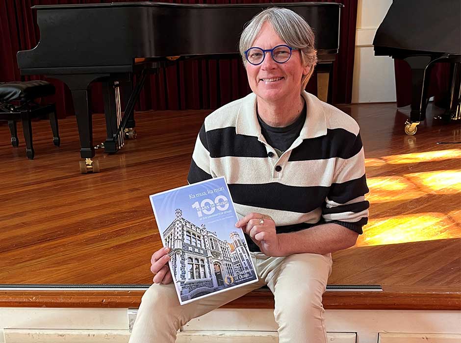 A man seated holding a book 