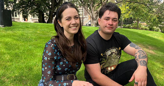 Two people seated next to each other on lawn