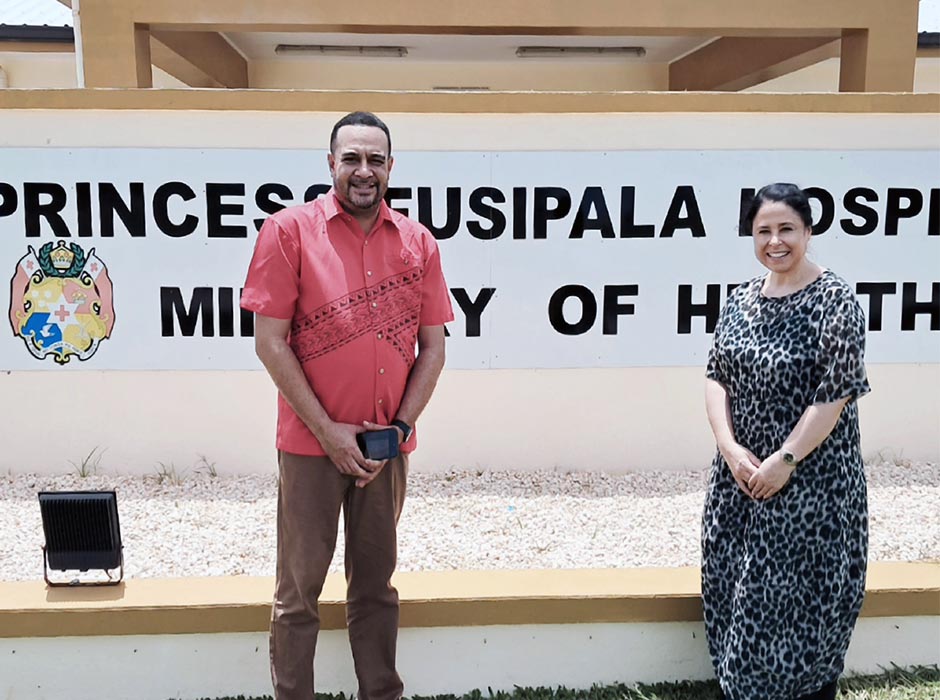 A man and woman standing in front of a sign