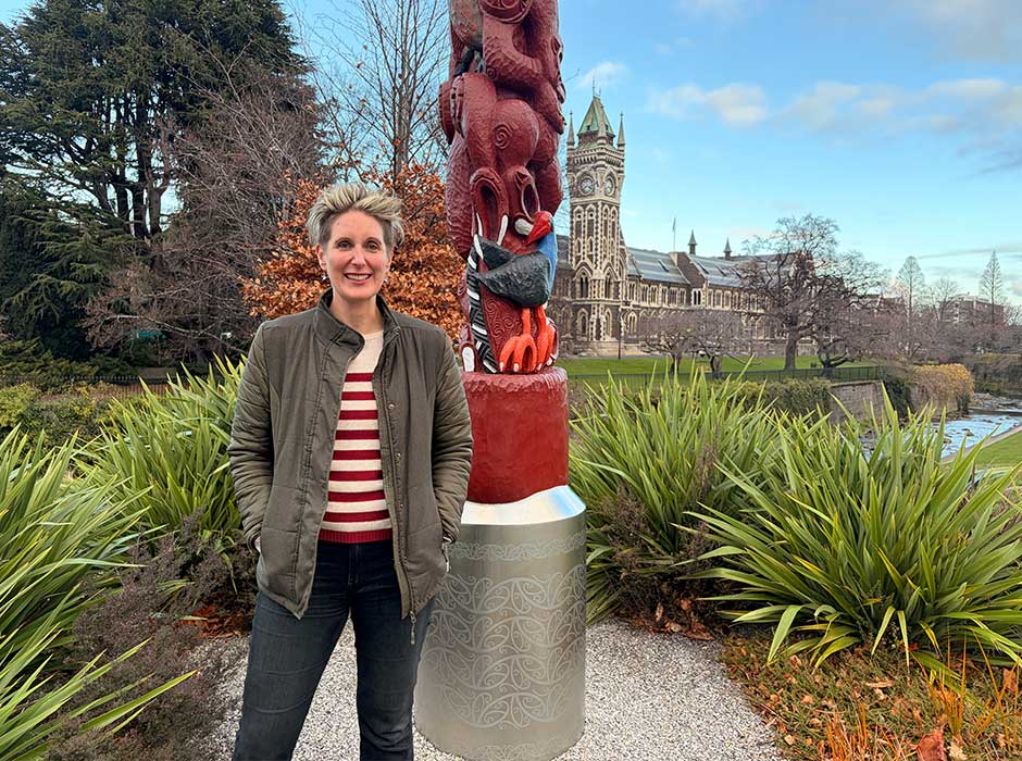 a woman standing in front of the pou by Water of Leith in front of the clocktower