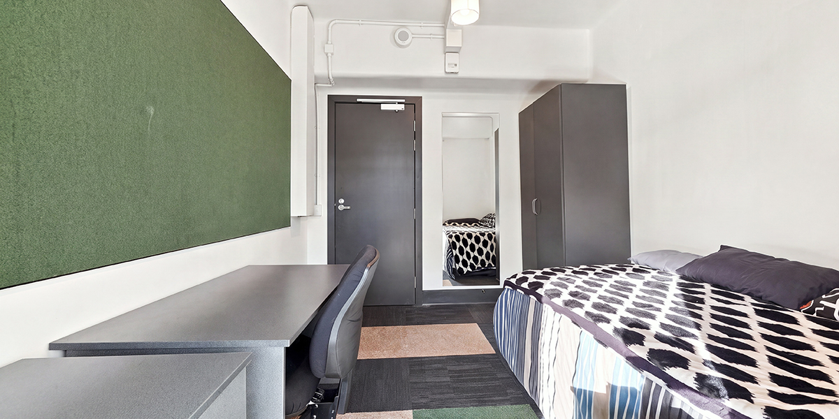 Bed and desk in one of the student bedrooms