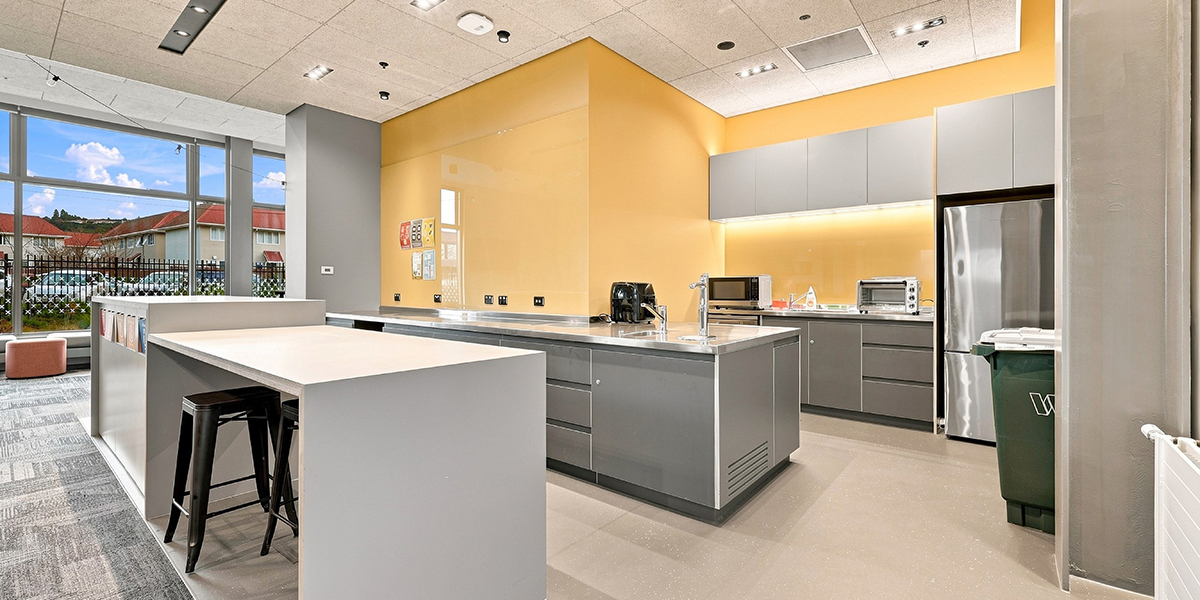 Shared kitchen - grey with stainless steel fridge and yellow walls