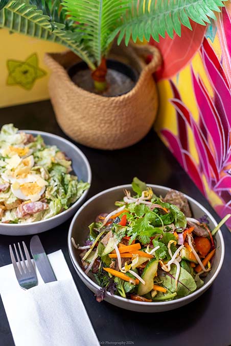Two bowls of salads with a knife and fork