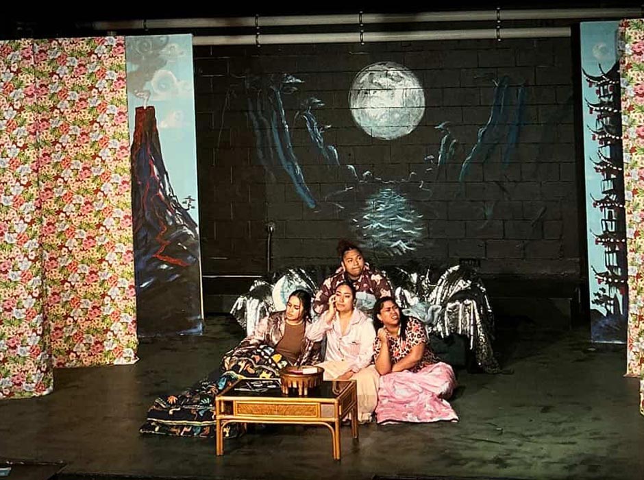 Four women perform on a stage.
