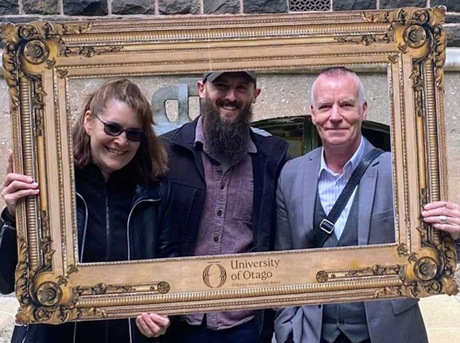 three people inside a cardboard frame