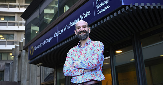 A photo of Professor William-Levack in front of the Wellington campus entrance