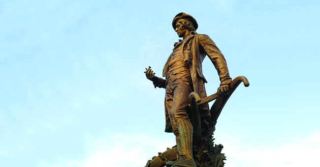 Robert Burns statue with blue sky in background