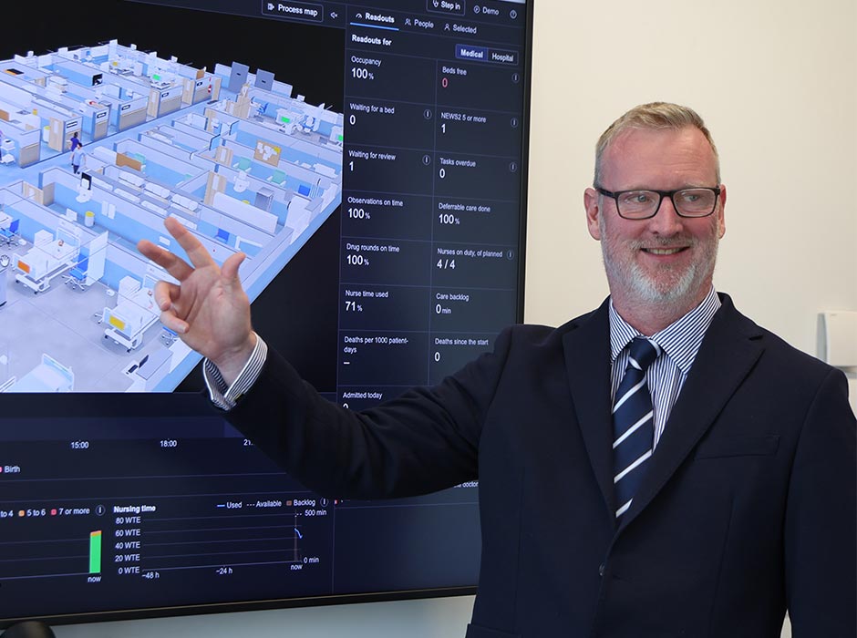 Associate Professor Chris Paton pictured in front of a prototype for a 3D agent-based hospital simulator.