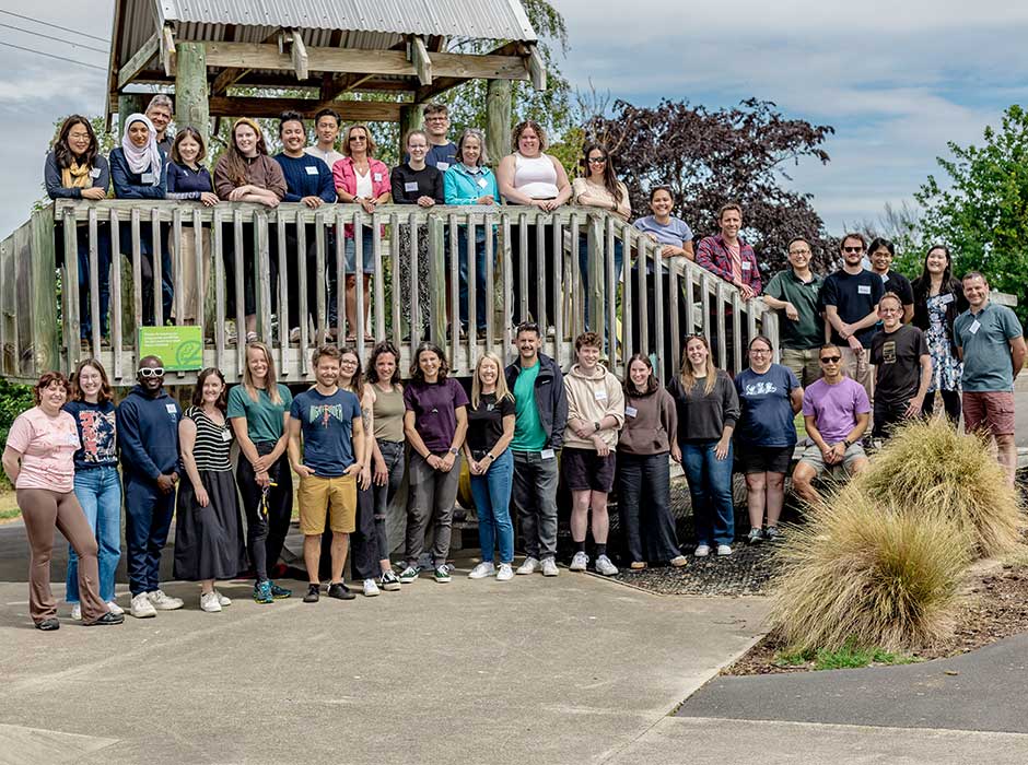 Two rows of people standing in and in front of a wooden fort 