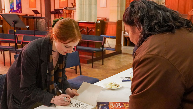 An author signs a book.