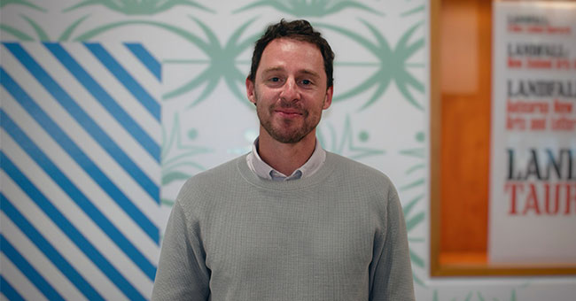 A man standing in front of a wall 