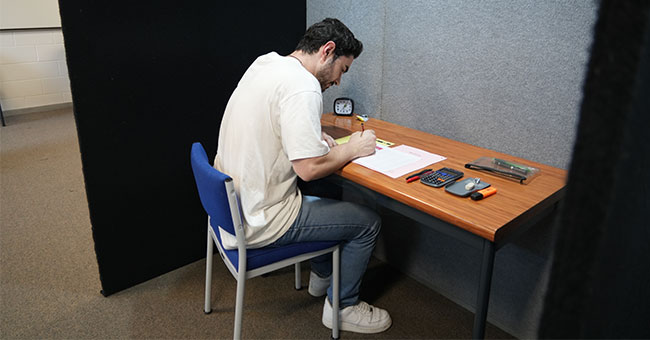 Tauira Nate Hamilton, demonstrating one of the new spaces, says the booth gave him peace of mind and no distractions during his actual exam.