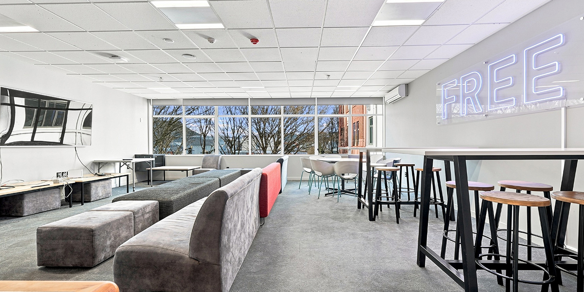 Common room with tables, chairs, sofas and large TV