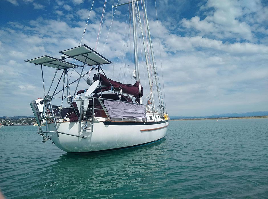 A vessel sails on a calm, sunny day.